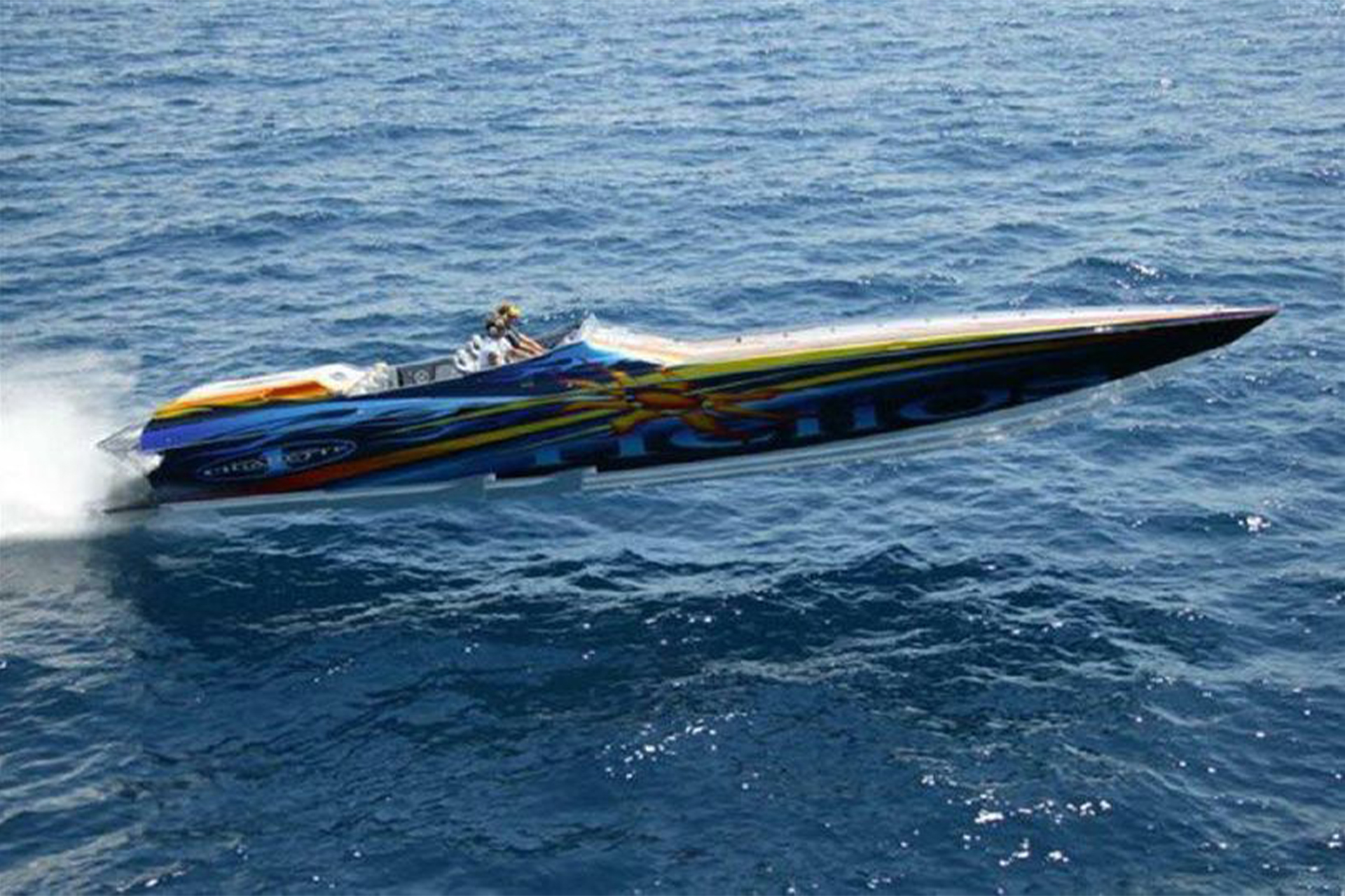 Custom blue cigarette boat speeding through water.