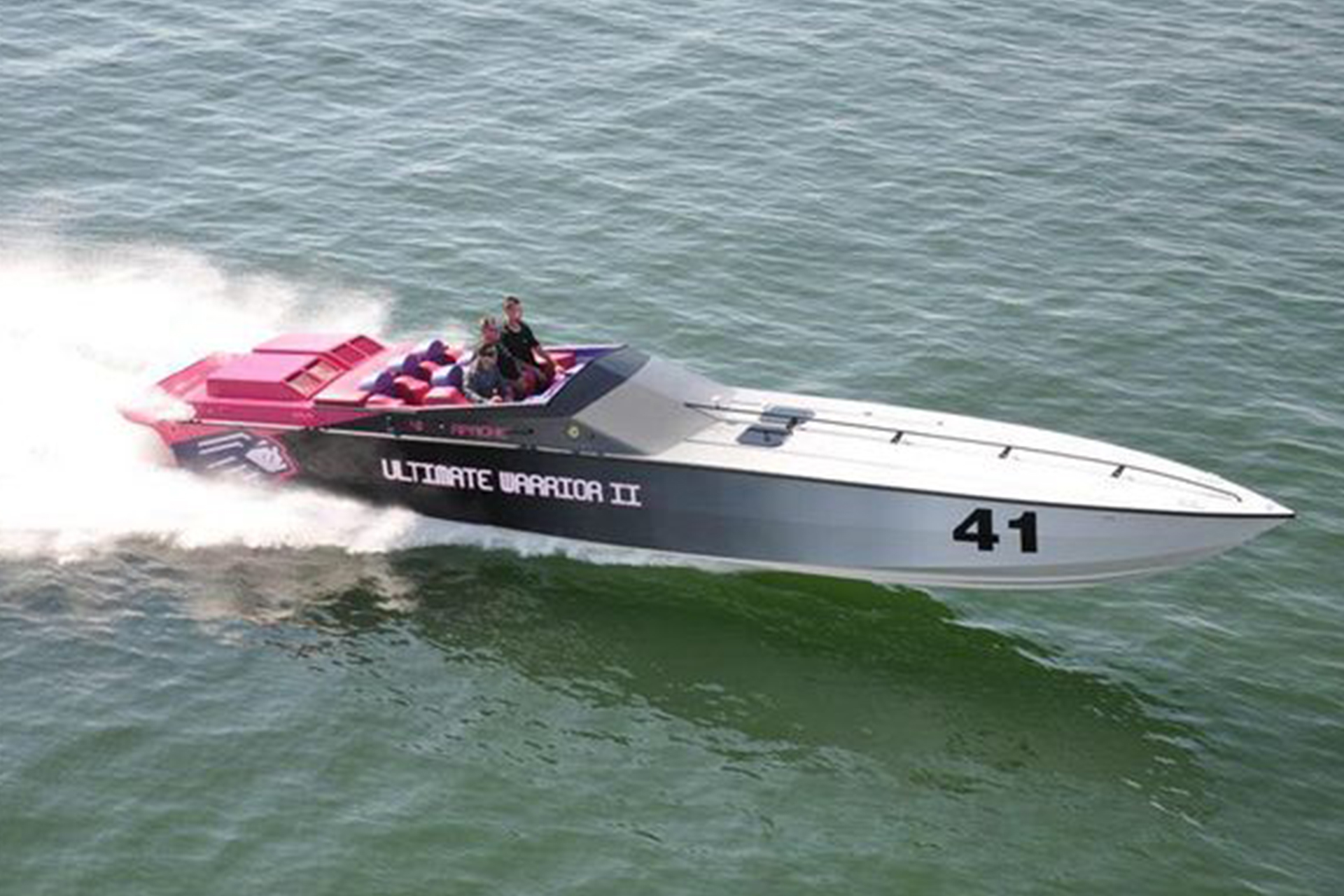 Custom Ultimate Warrior II boat speeding on water.